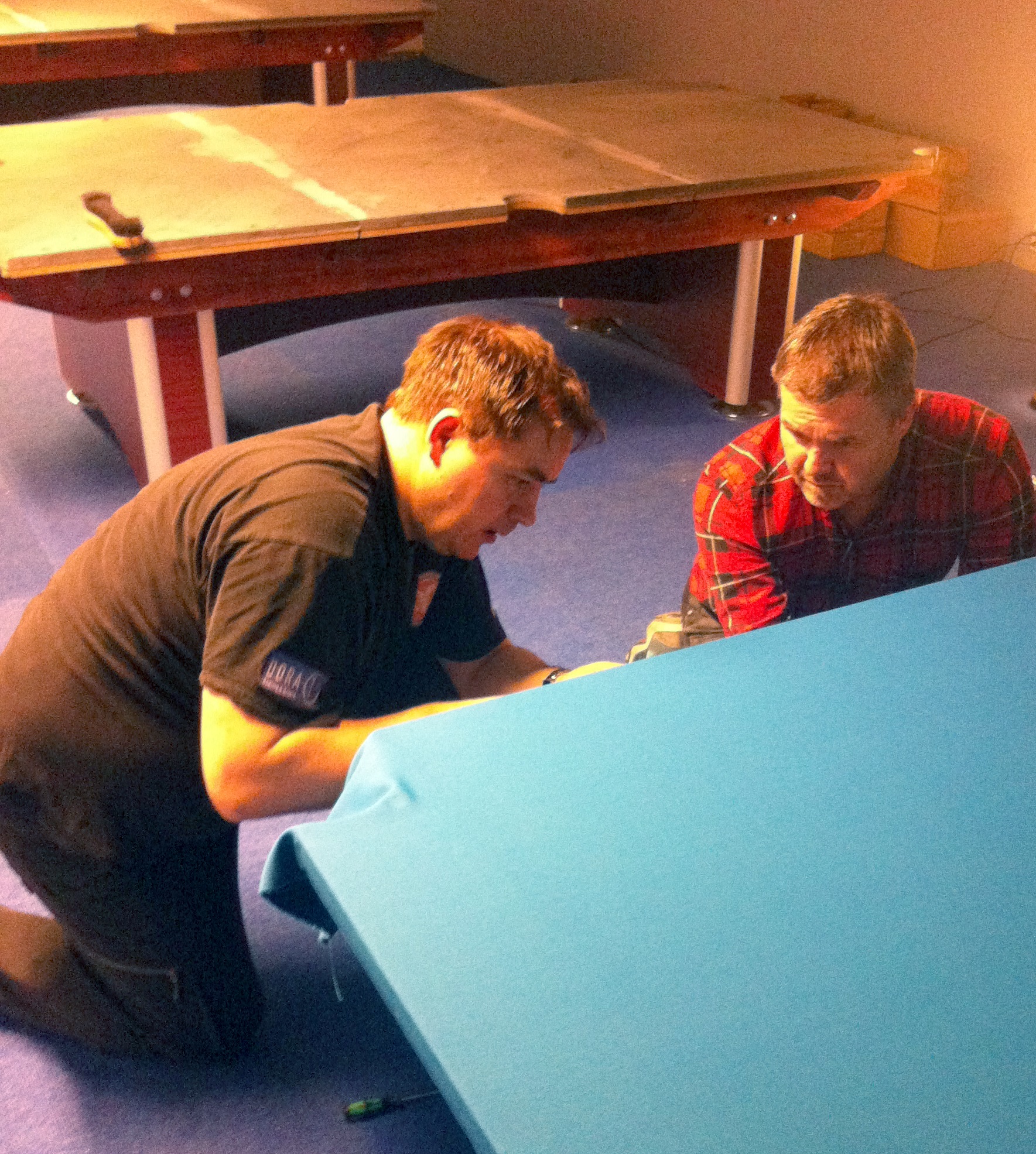 Roger og Geir jobber med å feste duken på det første bordet. Vi gjorde det på samme måte som på et snooker-bord.